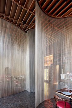 the interior of a restaurant with sheer curtains on the walls and tables in the middle