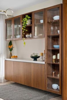 a kitchen with wooden cabinets and white counter tops next to a large potted plant