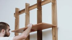 a man is working on a wooden shelf