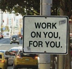 a sign that says work on you, for you next to a busy city street