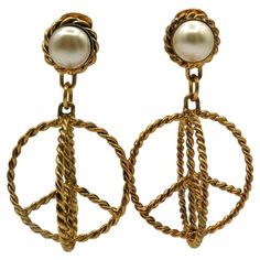 MOSCHINO vintage antiqued gold tone breaded metal dangling earrings (clip-on) featuring a large 3-dimensional peace sign topped by a faux pearl. Embossed MOSCHINO. Indicative measurements : height approx. 7.5 cm (2.95 inches) / max. width approx. 3.2 cm (1.26 inches). Weight per earring approx. 20 grams. Material : Gold tone metal hardware / Glass. NOTES - This is a preloved vintage item, therefore it might have imperfections. - Colors may differ slightly from actual product appearance due to di Vintage Gold-plated Jewelry With Dangling Charms, Moschino Earrings, Vintage Metal Dangle Clip-on Earrings, Vintage Yellow Dangle Earrings, Moschino Vintage, Vintage Yellow Gold Dangling Charms, Crystal Belt, Dangling Earrings, Metal Hardware