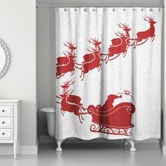 a shower curtain with santa's sleigh and reindeers in red on white