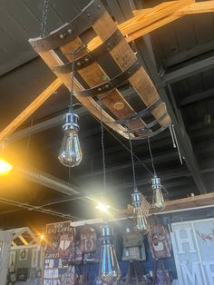 several light bulbs hanging from the ceiling in a store with wooden crates and signs on it