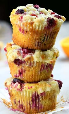 three muffins stacked on top of each other with cranberries and blueberries