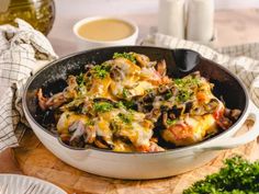 a skillet filled with food on top of a wooden cutting board