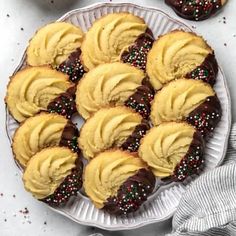 chocolate covered cookies on a plate with sprinkles