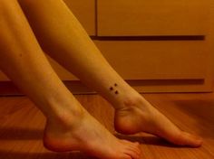 a person's foot with a small star tattoo on it