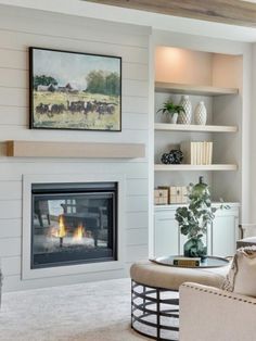 a living room filled with furniture and a fire place under a painting on the wall