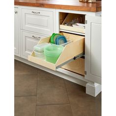 an open drawer in a kitchen filled with dishes