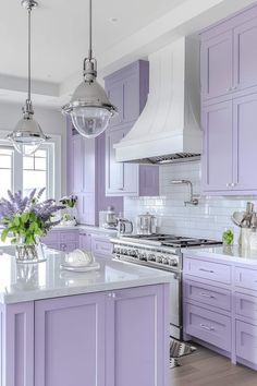 a kitchen with purple cabinets and white counter tops, along with a center island in the middle