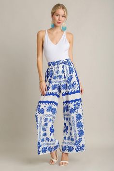 Royal blue and ivory floral print textured wide leg pants Get inspired this season with these stunning ivory and royal blue floral print pants! Featuring a textured fabric with wide legs and an elastic waistband with drawstring. Feel trendy and fashionable at all of your upcoming events! Perfect dressed up with heels and a bodysuit, or worn casually with sandals and a tank top. Shop the look: white eyelet top True to size fit; wide relaxed leg Model is 5'9" wearing a small Fabric doesn't contain White Eyelet Top, Leg Model, Floral Print Pants, Dressy Pants, Eyelet Top, Vintage Couture, Print Pants, Clothing Logo, White Eyelet