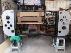 two video game controllers sitting next to each other on top of stools in a garage