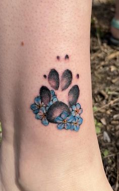 a foot with a paw and blue flowers on it