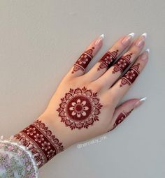 a woman's hand with henna tattoos on it