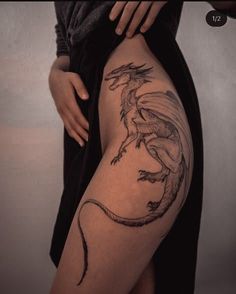 a woman's thigh with a dragon tattoo on it