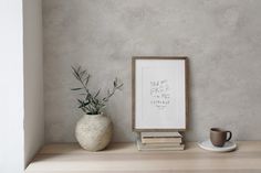 a white vase sitting on top of a wooden shelf next to a cup and saucer