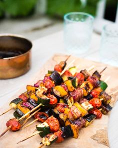 grilled vegetables on skewers sitting on a cutting board