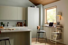 a kitchen with two stools next to a counter