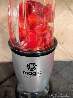 a blender filled with strawberries on top of a counter