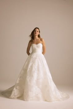 a woman in a wedding dress posing for the camera with her hands on her hips