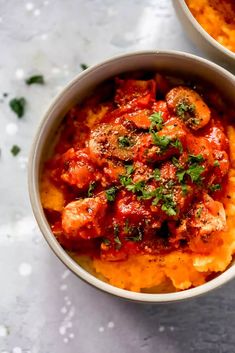 two bowls filled with food on top of a table