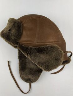 A classical and a very practical hat can now accompany you in a daily basis . Proposed for men of every age. A great option for any outdoor activity . Very comfortable and easy to wear . An Aviator Napa Sheepskin hat with earflaps and leather strings. Light brown exterion and soft merinos sheepskin wool . Keep yourselves warm & classy This great everyday hat is made of light brown napalan sheepskin , the outer part , and soft brown merinos sheepskin wool the inner and front part . It is very lig Leather Hat With Ear Flaps For Outdoor, Brown Sheepskin Hat With Faux Fur Lining, Leather Hats With Faux Fur Lining And Ear Flaps, Brown Hat With Faux Fur Lining And Ear Flaps, Brown Hats With Faux Fur Lining And Ear Flaps, Brown Leather Hats With Faux Fur Lining, Brown Aviator Winter Hats, Winter Brown Aviator Hats, Brown Winter Hats