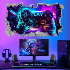 a computer desk with a gaming controller on it and a wall sticker that says play