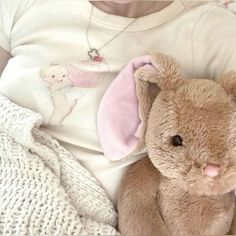 a baby is laying down with a stuffed animal