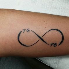 a close up of a person's arm with a tattoo on it that has an infinite symbol