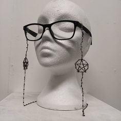 Hex glasses chain Brand new! Jazz up those spectacles with these beautiful chains. Adorned with a large pentagram and branch design. Suitable for all glasses types. The elastic loops fit comfortably on your frames without causing damage. Wear them near the front to make a statement or further back on your frames to appear like earrings.  Never lose your glasses again as this makes it easier to wear your glasses around your neck or even ontop of your head with the chains as a hanging decoration. Black Metal Adjustable Glasses Chain, Black Metal Glasses Chain With Adjustable Feature, Black Metal Glasses Chains With Adjustable Chain, Black Metal Glasses Chain With Adjustable Length, Silver Glass Glasses Chains For Festival, Handmade Silver Metal Glasses Chains, Handmade Silver Glasses Chains For Festival, Glasses Types, Gothic Glasses