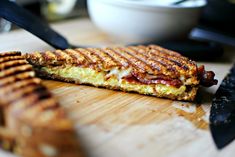 a grilled sandwich sitting on top of a wooden cutting board