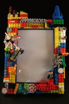 a frame made out of legos on a black table with a white board in the middle