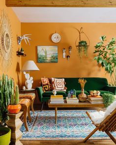 a living room with yellow walls and green couches, potted cacti