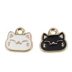 two charms with black and white cats on the front, one has a cat's head