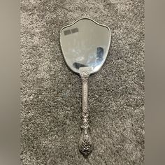 an antique looking mirror is laying on the floor in front of a carpeted area