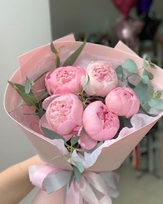 a person holding a bouquet of pink flowers