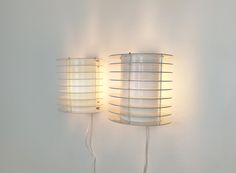 two lamps that are on the wall next to each other, one has a wire wrapped around it