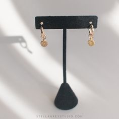 The Oriana gold huggie hoop earrings are a beautiful, delicate addition to anyone's accessory game. The hoops are approx. 15mm and gold filled, suitable for sensitive skin. The charms are approx. 8mm and gold vermeil with a brushed finish, and a stamped star is accented with a tiny CZ stone. 14k gold filled hoops, suitable for sensitive skin Brushed gold vermeil starburst charm 14k Gold-filled Yellow Gold Cartilage Earrings, Gold Plated Dangle Huggie Earrings For Everyday, 14k Gold Filled Gold Cartilage Earrings, Dainty 14k Yellow Gold Filled Huggie Earrings, Hypoallergenic 14k Gold Filled Dangle Huggie Earrings, Hypoallergenic 14k Gold Filled Rose Gold Huggie Earrings, 14k Yellow Gold Filled Dangle Huggie Earrings, Dainty Gold Plated Tarnish Resistant Huggie Earrings, Everyday 14k Gold Filled Dangle Cartilage Earrings