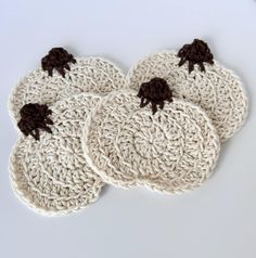 four crocheted coasters with black bows on them sitting on a white surface