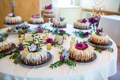 a table topped with cakes covered in icing and flowers on top of each cake