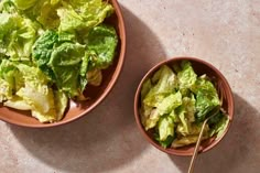 two bowls filled with lettuce next to each other on a counter top,