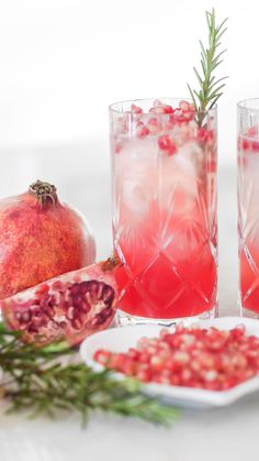 two pomegranates in glasses with rosemary garnish