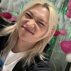 a woman with long blonde hair smiling at the camera