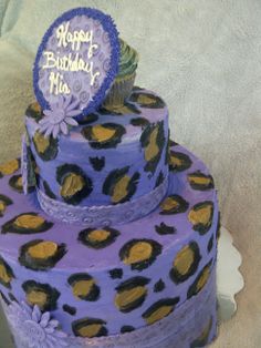 a three tiered cake with purple and gold decorations