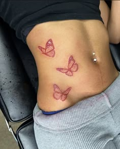 a woman's stomach with three pink butterflies on it