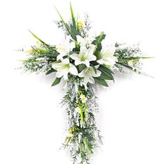 a cross decorated with white flowers and greenery