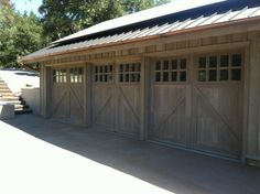 a wooden garage with two doors and windows