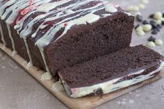 a chocolate cake with white frosting and sprinkles on a cutting board