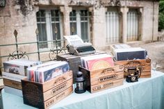 a table topped with wooden boxes and typewriters on top of a blue cloth covered table