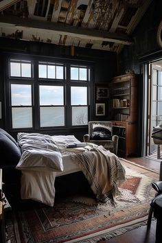 a bedroom with a large bed and lots of windows in it's walls, along with a rug on the floor